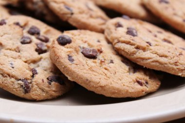 Çikolatalı kurabiyeler açık kahverengi bir tabakta hazırlanır ve çocuklara servis edilmeye hazırdır..