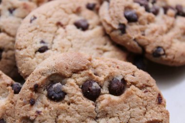 Çikolatalı kurabiyeler açık kahverengi bir tabakta hazırlanır ve çocuklara servis edilmeye hazırdır..