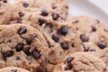 Çikolatalı kurabiyeler açık kahverengi bir tabakta hazırlanır ve çocuklara servis edilmeye hazırdır..