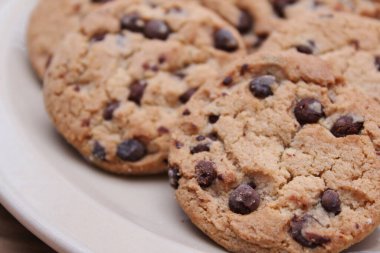 Çikolatalı kurabiyeler açık kahverengi bir tabakta hazırlanır ve çocuklara servis edilmeye hazırdır..
