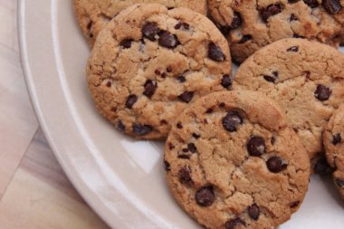 Çikolatalı kurabiyeler açık kahverengi bir tabakta hazırlanır ve çocuklara servis edilmeye hazırdır..