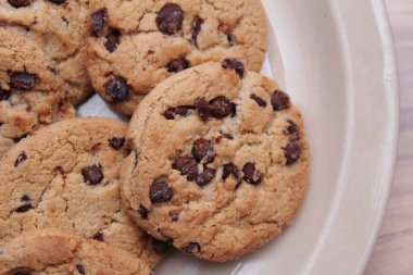 Çikolatalı kurabiyeler açık kahverengi bir tabakta hazırlanır ve çocuklara servis edilmeye hazırdır..
