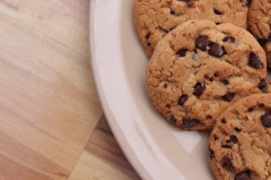 Çikolatalı kurabiyeler açık kahverengi bir tabakta hazırlanır ve çocuklara servis edilmeye hazırdır..