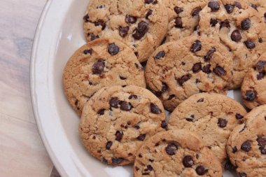 Çikolatalı kurabiyeler açık kahverengi bir tabakta hazırlanır ve çocuklara servis edilmeye hazırdır..