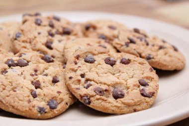 Çikolatalı kurabiyeler açık kahverengi bir tabakta hazırlanır ve çocuklara servis edilmeye hazırdır..