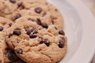 Çikolatalı kurabiyeler açık kahverengi bir tabakta hazırlanır ve çocuklara servis edilmeye hazırdır..