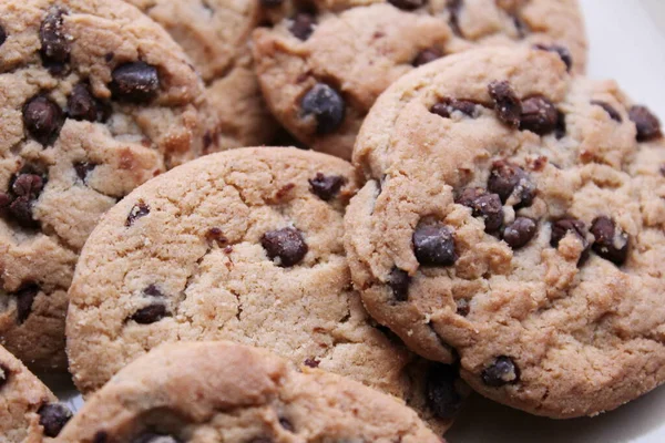 Çikolatalı kurabiyeler açık kahverengi bir tabakta hazırlanır ve çocuklara servis edilmeye hazırdır..