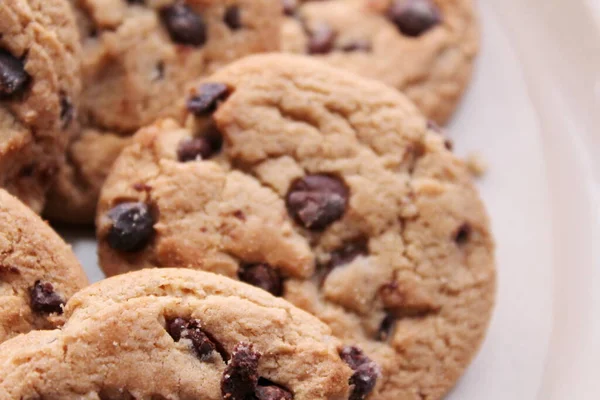 Çikolatalı kurabiyeler açık kahverengi bir tabakta hazırlanır ve çocuklara servis edilmeye hazırdır..