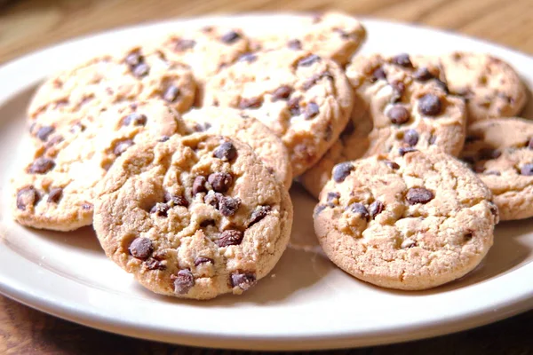 Çikolatalı kurabiyeler açık kahverengi bir tabakta hazırlanır ve çocuklara servis edilmeye hazırdır..