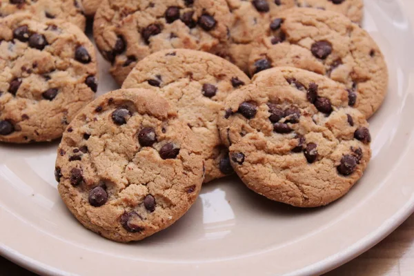 Çikolatalı kurabiyeler açık kahverengi bir tabakta hazırlanır ve çocuklara servis edilmeye hazırdır..
