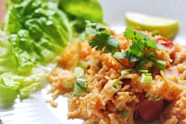 Yakın plan, domuz eti ve kızarmış pilav marul ve kişniş garnitürle servis edilir. Kızarmış pirinç Tayland 'da satılan bir sokak yiyeceğidir..