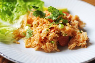 Yakın plan, domuz eti ve kızarmış pilav marul ve kişniş garnitürle servis edilir. Kızarmış pirinç Tayland 'da satılan bir sokak yiyeceğidir..