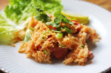 Yakın plan, domuz eti ve kızarmış pilav marul ve kişniş garnitürle servis edilir. Kızarmış pirinç Tayland 'da satılan bir sokak yiyeceğidir..