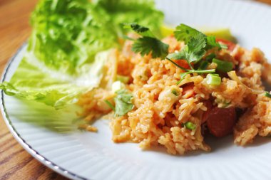 Yakın plan, domuz eti ve kızarmış pilav marul ve kişniş garnitürle servis edilir. Kızarmış pirinç Tayland 'da satılan bir sokak yiyeceğidir..