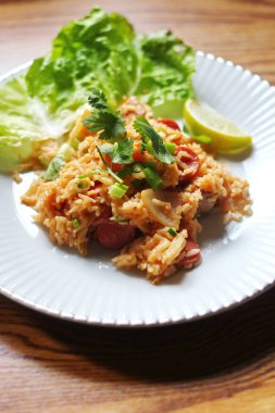 Dikey resim, domuz eti ve kızarmış pilav marul ve kişniş garnitürle servis edilir. Kızarmış pirinç Tayland 'da satılan bir sokak yiyeceğidir..