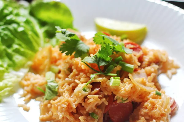 Yakın plan, domuz eti ve kızarmış pilav marul ve kişniş garnitürle servis edilir. Kızarmış pirinç Tayland 'da satılan bir sokak yiyeceğidir..