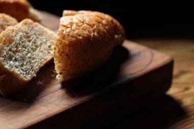 Servise hazır taze buğday bolioları ahşap bir kesme tahtasıyla kesildi..