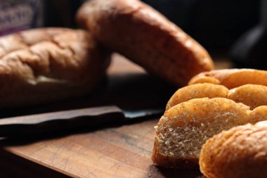 Servise hazır taze buğday bolioları ahşap bir kesme tahtasıyla kesildi..