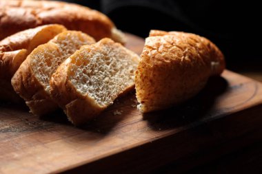 Servise hazır taze buğday bolioları ahşap bir kesme tahtasıyla kesildi..
