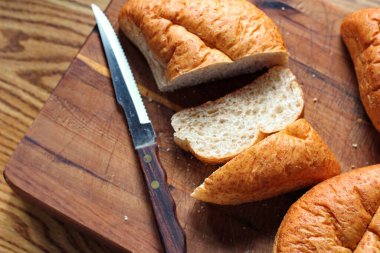 Ekmek tahta bir kesme tahtasıyla dilimleniyor. Taze yapılmış bir ekmek. Fotoğraf: Düz Düz Düz