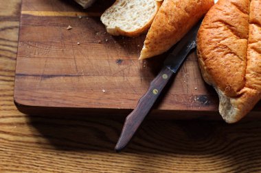 Ekmek tahta bir kesme tahtasıyla dilimleniyor. Taze yapılmış bir ekmek. Fotoğraf: Düz Düz Düz