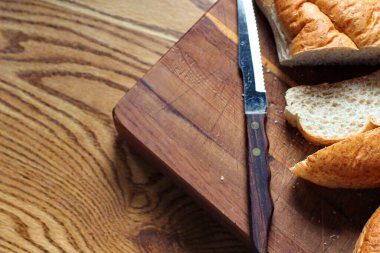 Ekmek tahta bir kesme tahtasıyla dilimleniyor. Taze yapılmış bir ekmek. Fotoğraf: Düz Düz Düz