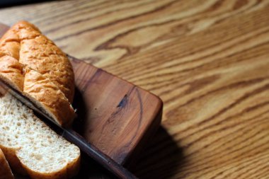 Ahşap bir masaya yerleştirilmiş fırınlanmış ekmek. Düz fotograf.