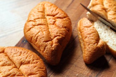 Ahşap bir masaya yerleştirilmiş fırınlanmış ekmek. Düz fotograf.