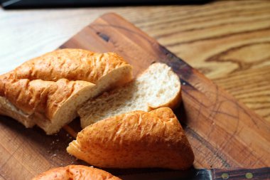 Ahşap bir masaya yerleştirilmiş fırınlanmış ekmek. Düz fotograf.