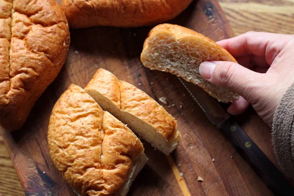 Ekmek tahta bir kesme tahtasıyla dilimleniyor. Taze yapılmış bir ekmek. Fotoğraf: Düz Düz Düz
