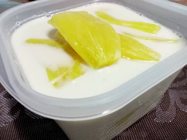 Hindistan cevizi sütlü Jackfruit, sarı, lezzetli, plastik bir kutuya konur..