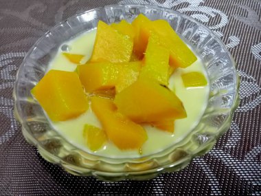 Hindistan cevizi sütlü balkabağı, sarı, iştah açıcı ahşap bir masada güzel bir cam bardakta servis edilir..