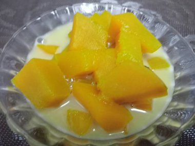 Hindistan cevizi sütlü balkabağı, sarı, iştah açıcı ahşap bir masada güzel bir cam bardakta servis edilir..