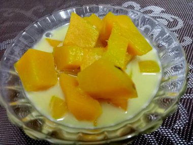 Hindistan cevizi sütlü balkabağı, sarı, iştah açıcı ahşap bir masada güzel bir cam bardakta servis edilir..