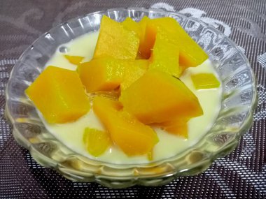 Hindistan cevizi sütlü balkabağı, sarı, iştah açıcı ahşap bir masada güzel bir cam bardakta servis edilir..