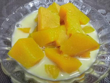 Hindistan cevizi sütlü balkabağı, sarı, iştah açıcı ahşap bir masada güzel bir cam bardakta servis edilir..