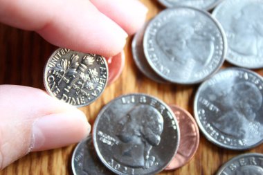 Dolar sikkeleri ve dolar banknotları tahtadan bir masaya saçılmış, düz dolar paraları..