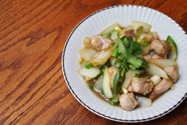 Kızarmış domuz eti ile soğan ve taze soğan karışımı beyaz tabakta servis edilen Tayland yemeği Taylandlıların yediği popüler bir yemektir..