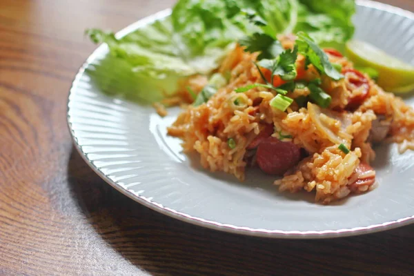 Marul ve kişniş garnitürle servis edilen bir tabakta domuz eti ve kızarmış pilav. Kızarmış pirinç Tayland 'da satılan bir sokak yiyeceğidir..