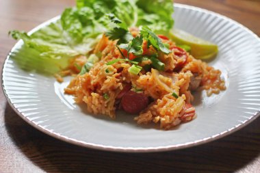 Marul ve kişniş garnitürle servis edilen bir tabakta domuz eti ve kızarmış pilav. Kızarmış pirinç Tayland 'da satılan bir sokak yiyeceğidir..
