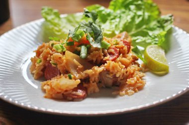 Marul ve kişniş garnitürle servis edilen bir tabakta domuz eti ve kızarmış pilav. Kızarmış pirinç Tayland 'da satılan bir sokak yiyeceğidir..