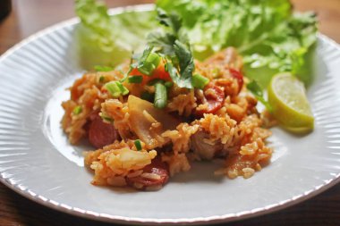 Marul ve kişniş garnitürle servis edilen bir tabakta domuz eti ve kızarmış pilav. Kızarmış pirinç Tayland 'da satılan bir sokak yiyeceğidir..