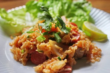 Marul ve kişniş garnitürle servis edilen bir tabakta domuz eti ve kızarmış pilav. Kızarmış pirinç Tayland 'da satılan bir sokak yiyeceğidir..