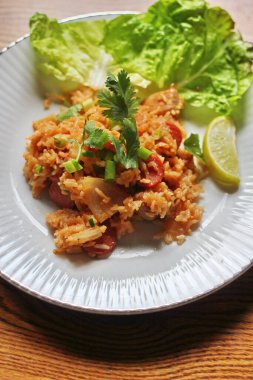 Marul ve kişniş garnitürle servis edilen bir tabakta domuz eti ve kızarmış pilav. Kızarmış pirinç Tayland 'da satılan bir sokak yiyeceğidir..