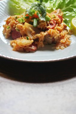 Marul ve kişniş garnitürle servis edilen bir tabakta domuz eti ve kızarmış pilav. Kızarmış pirinç Tayland 'da satılan bir sokak yiyeceğidir..