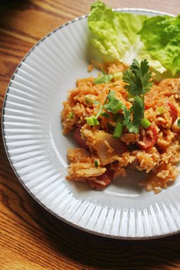 Marul ve kişniş garnitürle servis edilen bir tabakta domuz eti ve kızarmış pilav. Kızarmış pirinç Tayland 'da satılan bir sokak yiyeceğidir..
