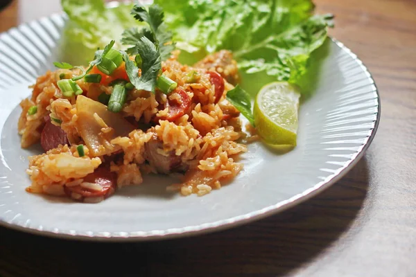Marul ve kişniş garnitürle servis edilen bir tabakta domuz eti ve kızarmış pilav. Kızarmış pirinç Tayland 'da satılan bir sokak yiyeceğidir..