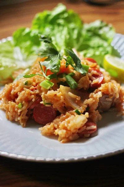 Marul ve kişniş garnitürle servis edilen bir tabakta domuz eti ve kızarmış pilav. Kızarmış pirinç Tayland 'da satılan bir sokak yiyeceğidir..