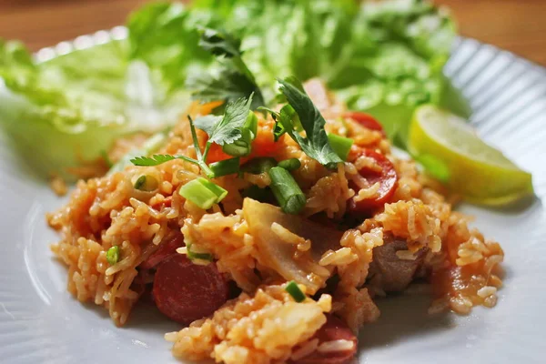 Marul ve kişniş garnitürle servis edilen bir tabakta domuz eti ve kızarmış pilav. Kızarmış pirinç Tayland 'da satılan bir sokak yiyeceğidir..