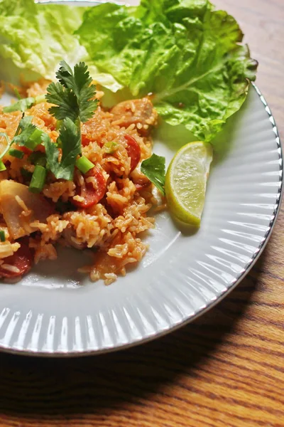 Marul ve kişniş garnitürle servis edilen bir tabakta domuz eti ve kızarmış pilav. Kızarmış pirinç Tayland 'da satılan bir sokak yiyeceğidir..